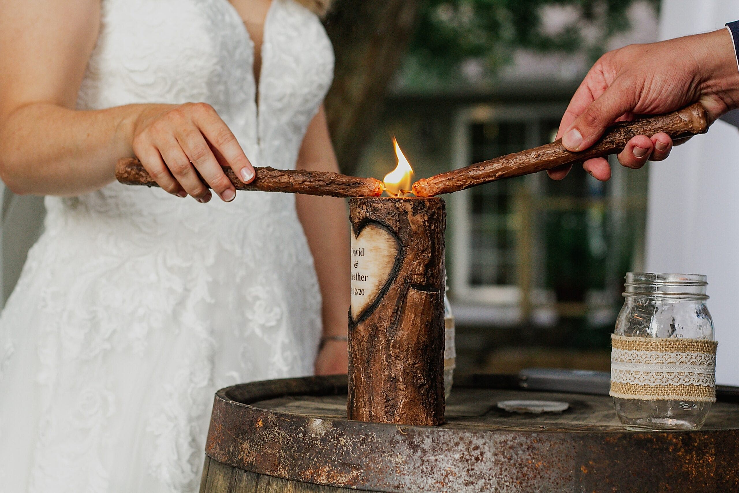 A newly married couple lights a candle using 2 other candles during a unity ceremony
