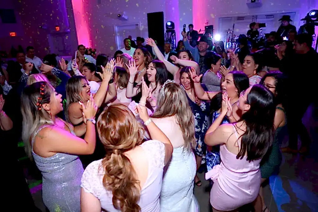 Guests dance under statement lighting at an indoor wedding venue in Dallas, Texas