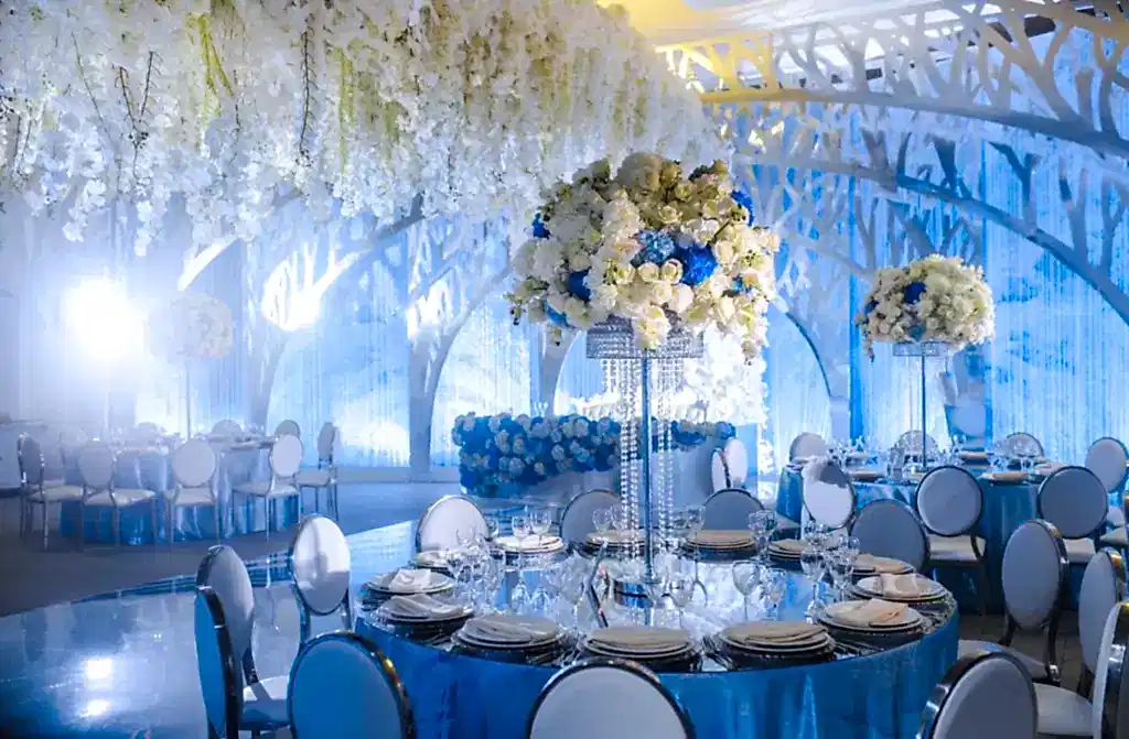 A wedding venue with winter floral arrangements, colors, and white lighting