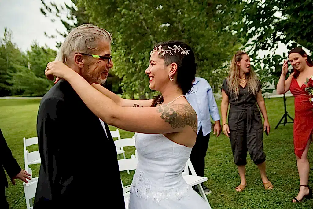A father and daughter begin to dance to their father-daughter dance song.