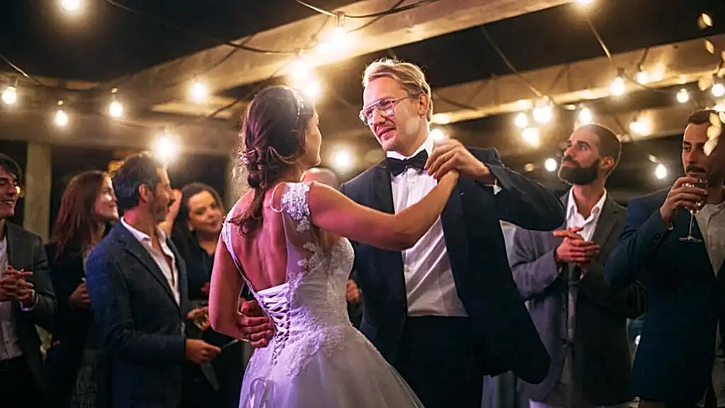 A bride in a white dress and a groom in a sharp suit dance